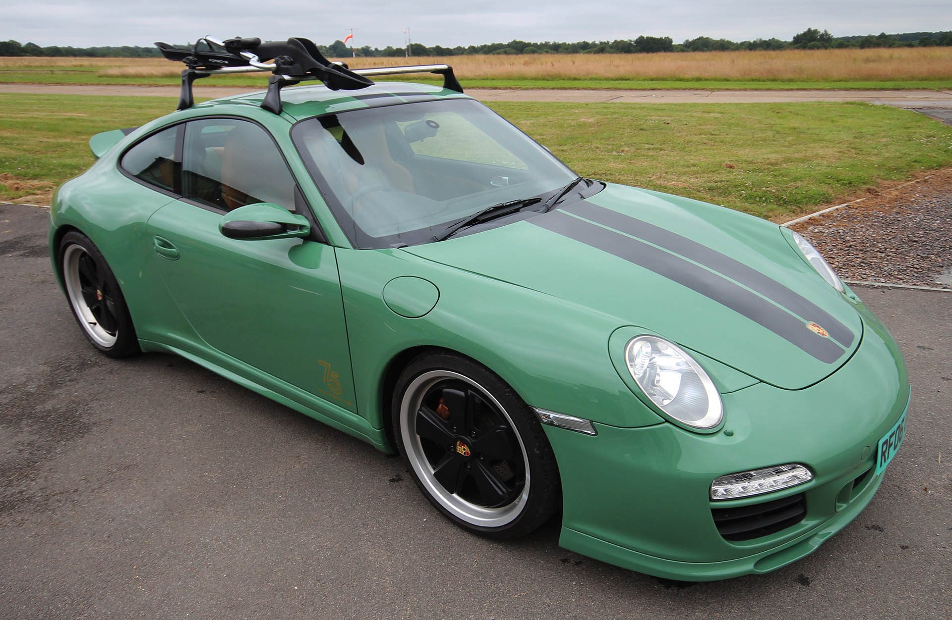 Porsche 911 997 model Sports Classic conversion by Designls ltd in Auratium green custom repaint exterior featuring fitted full body kit with black Fuchs alloy wheels and heritage livery